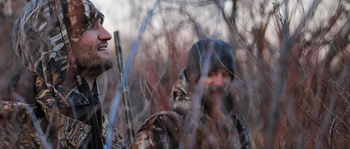 Two hunters hiding in tall grasses